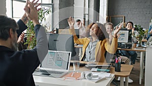 Young Afro-American businesswoman expressing happiness in office while colleagues applauding
