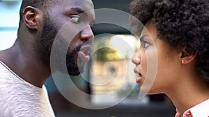 Young afro-american couple arguing outdoor, misunderstanding, jealous spouse