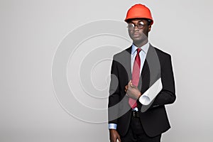 Young Afro-American engineer with blueprints on white background