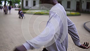 A young afro american guy throws a soccer ball with his feet. Guy in headphones warming up in the fresh air, playing