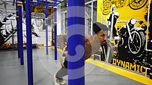 Young afro american sportsman doing exercises on trx equipment at sport club. Muscular african athlete hard training at