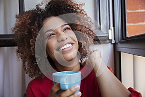 Young afro american woman relaxing with tea at home.