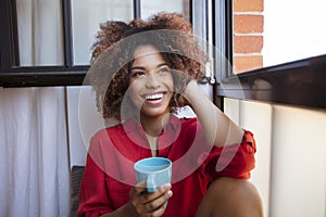 Young afro american woman relaxing with tea at home.