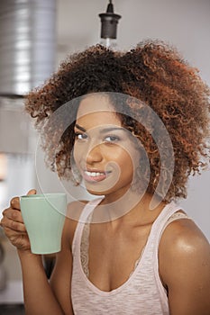 Young afro american woman relaxing with tea at home.