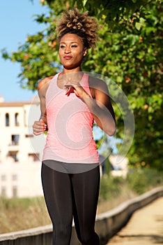 Young afro american woman running outdoors in morning