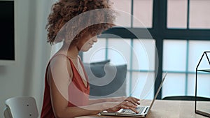 Young Afro American woman using laptop computer while sitting at table.