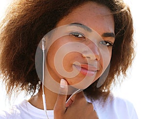 Young afro american young woman listening to music in headphones. Close up portrait. Lifestyle.