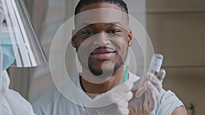 Young afro male patient african american man smiling says yes satisfied looking at hands in latex gloves doctor nurse