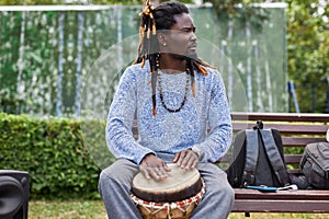Young afro man with djembe drums outdoors