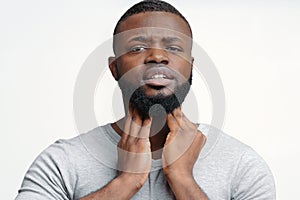 Young black guy suffering from chronic pharyngitis photo