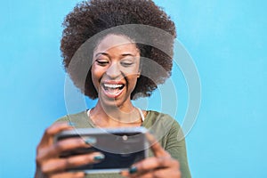 Young Afro woman using mobile smartphone - Happy African girl having fun with new trends technology apps