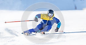 A young aggressive skier on an alpine slope demonstrates an extreme carving skiing style