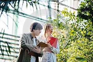 Young agricultural engineers working in greenhouse