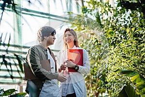 Young agricultural engineers working in greenhouse