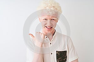 Young albino blond man wearing casual shirt standing over isolated white background pointing and showing with thumb up to the side