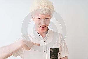 Young albino blond man wearing casual shirt standing over isolated white background with surprise face pointing finger to himself