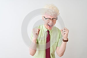 Young albino businessman wearing shirt and tie standing over isolated white background celebrating mad and crazy for success with
