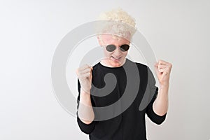 Young albino man wearing black t-shirt and sunglasess standing over isolated white background celebrating mad and crazy for