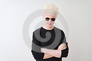 Young albino man wearing black t-shirt and sunglasess standing over isolated white background skeptic and nervous, disapproving