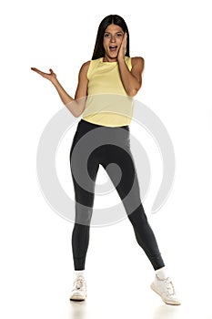 Young amazed advertizing woman in leggings photo