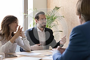 Young and ambitious employees engaged in briefing in boardroom