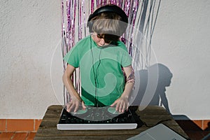 Young American boy near the DJ controller - the concept of DJing