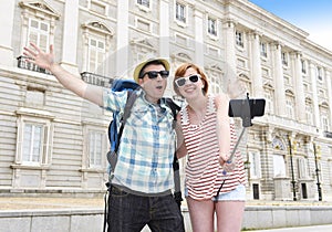 Young American couple enjoying Spain holiday trip taking selfie photo self portrait with mobile phone