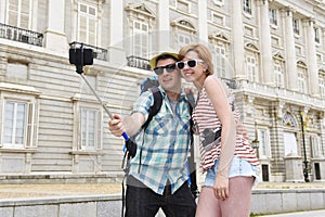 Young American couple enjoying Spain holiday trip taking selfie photo self portrait with mobile phone