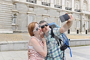 Young American couple enjoying Spain holiday trip taking selfie photo self portrait with mobile phone