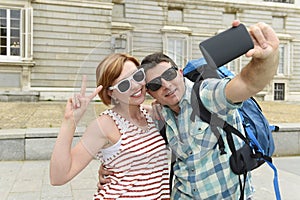 Young American couple enjoying Spain holiday trip taking selfie photo self portrait with mobile phone