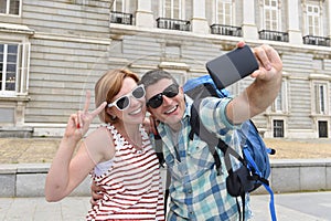 Young American couple enjoying Spain holiday trip taking selfie photo self portrait with mobile phone