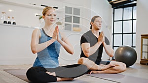 Young American couple in sportswear doing yoga exercise working out in kitchen at home at morning. Sport and recreation activity,