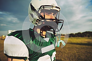 Young American football player taking a break during practice