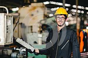 Young American happy labor worker enjoy smiling to work in industrial factory for heavy machine operator