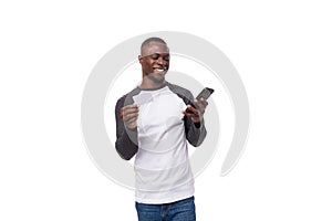 a young American man with a short haircut is dressed in a casual jacket with long sleeves holding a smartphone and a