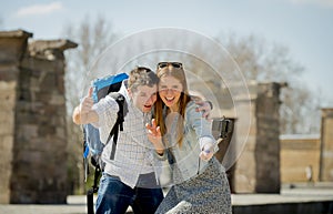 Young American student and tourist couple visiting Egyptian monument taking selfie photo with stick