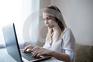 young american teen girl wear headphones video calling on laptop. pretty woman student looking at computer screen watching webinar