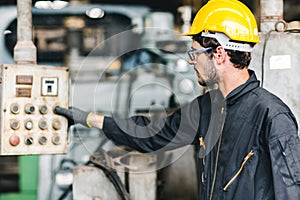 Young American worker intend to work in a heavy industrial factory.control the machine press the button