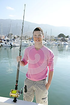 Young angler boat fisherman with rod and reel