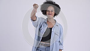Young angry African woman giving thumbs down