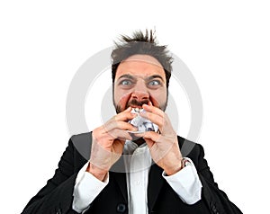 Young angry businessman while eating balled paper.