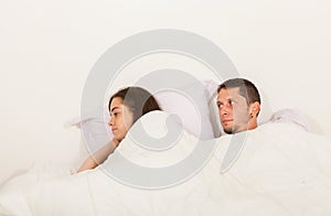 Young angry couple not talking to each other in bed with problems