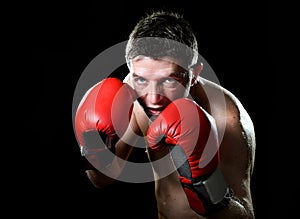 Young angry fighter man boxing with red fighting gloves in boxer stance