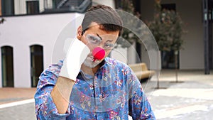 Young angry man mime actor threatening at camera, shaking fist, outdoor