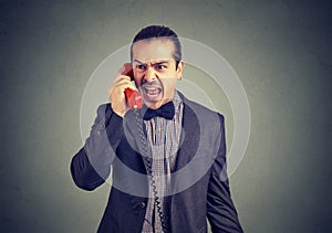 Young angry man yelling on the telephone