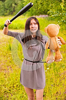 Young angry woman hitting toybear