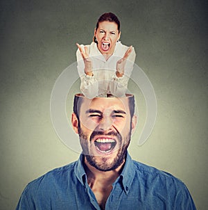 Young angry woman screaming inside head of a frustrated guy