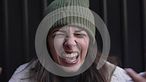 Young angry woman shouting arguing feeling betrayed, cheated and frustrated. Close up female looking at camera with negative