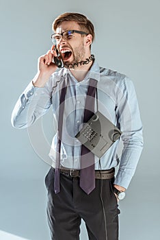 Young annoyed businessman screaming while talking