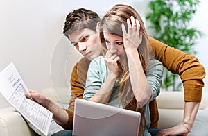Young anxious couple consults their bank account photo